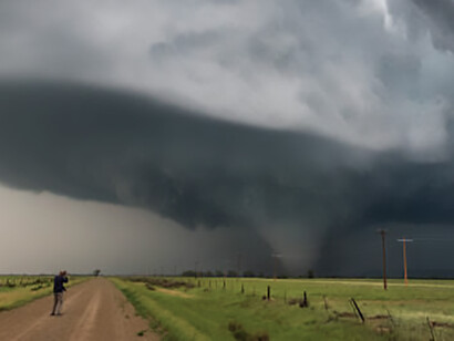 Storm chasers capture a tornado under a spectacular supercell storm along a dirt road in Montana, highlighting extreme weather events such as hurricanes, USA