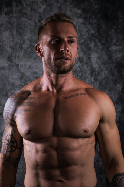 Shirtless man flexing muscular arms while using whey protein powder for fitness and muscle growth