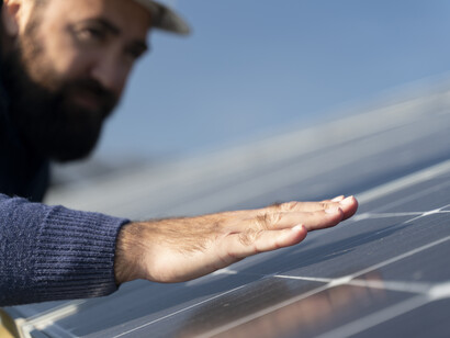 A bearded man measuring the heat of the surface of a panel
