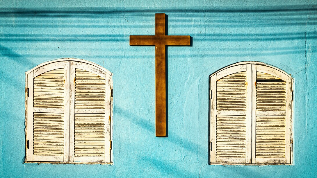 A wooden cross on a light blue wall