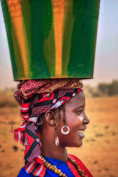 Burkina Faso – Ragazza trasporta un carico nei pressi di un villaggio Tuareg