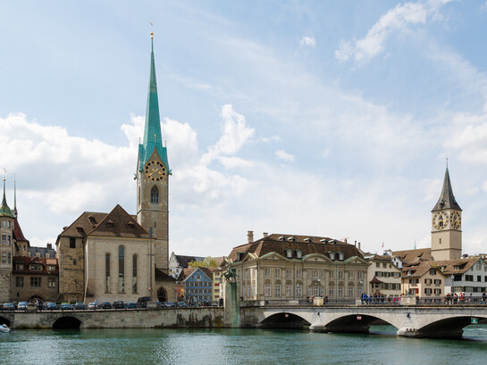 Zurich, Switzerland city view featuring Fraumünster Church, Zunfthaus zur Meisen, Münsterbrücke Bridge, and St. Peter Church in the historic Old Town skyline