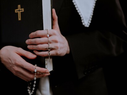 Hands clutching the Scriptures and symbols of faith, symbolising devotion that resists spiritual compromise
