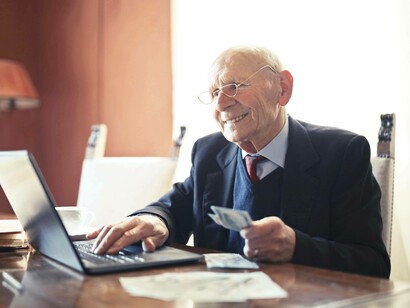 An elderly man smiling at his healthy position in the silver economy