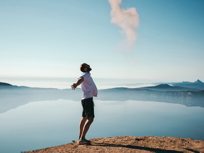 Hombre frente a un lago. Juega y ríe con la puerta abierta, así contagias de alegría al mundo que te observa