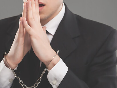 Image of a man with handcuffs on his hands, symbolizing incarceration and penal system reform