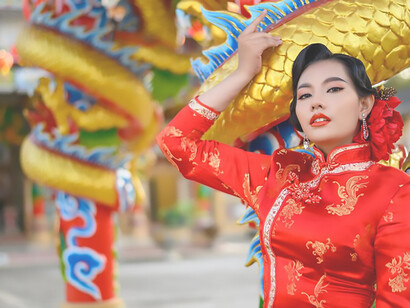 Capture the essence of Lunar New Year celebrations with a portrait of a beautiful Asian woman in a cheongsam, radiating joy and prosperity