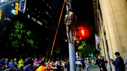 Manifestantes cuelgan una estatua arrancada del Monumento a la Confederación en el Capitolio del estado Carolina del Norte 