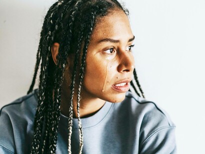 A woman shedding a tear and expressing emotion