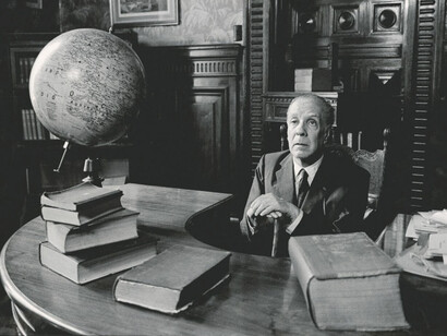 Jorge Luis Borges sitting at his a desk