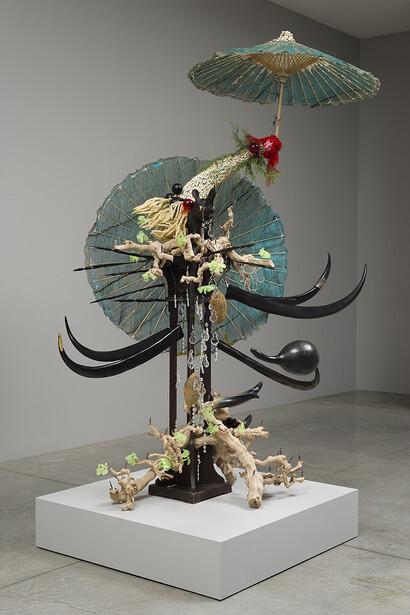 Rina Banerjee, Make me a summary of the world, she was his guide and had travelled on camel, rhino, elephant and kangaroo, dedicated to dried plants, glass houses - for medical study, vegetable sexuality, self-pollination, fertilization her reach pierced the woods country by country, 2014. Socle en bois, 2 ombrelles, six cornes et fausse vigne en plastique, poupée en céramique et coquillage, rhinocéros en bois, 243,9 x 106,7 cm, Courtesy de l’artiste et Galerie Nathalie Obadia, Paris/Bruxelles