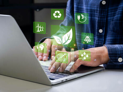 A person typing on a laptop with circular economy and sustainability icons, showcasing the connection between eco-friendly practices, recycling, and the alignment of environmental and business goals