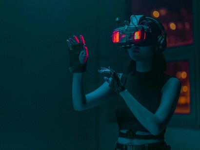 Mulher usa aparelho de realidade virtual. A escassez de profissionais qualificados na área da tecnologia é uma barreira ao progresso. Além disso, é necessário assegurar que o uso de IA respeite os valores éticos e os direitos dos cidadãos, algo que exige uma supervisão cuidadosa e legislação adaptada