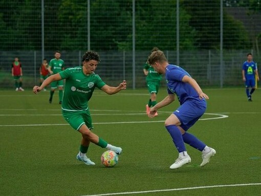 Two players engaged in a one-on-one fight for possession, representing the competitive intensity that increases football's global appeal