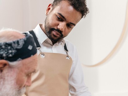 A waiter is helping a customer at the restaurant with his selection 