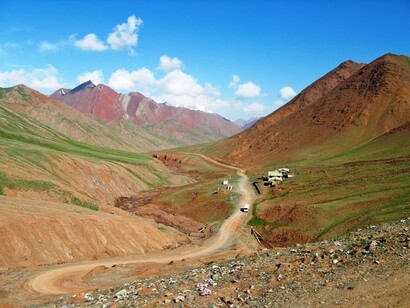 Discesa dall’Akbaytal Pass (4655m) verso il confine Kirghizo, indicato dal colosso del Pik Lenin (7134m) davanti a noi, qui semicoperto dalle nubi