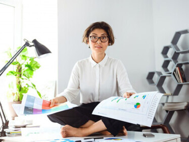 A businesswoman engaging in stress relief activities at her office desk, highlighting effective methods for managing work-related stress and promoting functional wellness