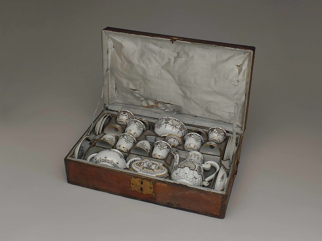 Vienna, Du Paquier, 1730. Servizio da tè e da caffè in 24 pezzi per 6 persone, con custodia originale, dipinto a motivi “Laub-und Bandelwerk” (foglie e intrecci) in “Schwarzlot” (monocromia nera) con rialzi in oro. 
