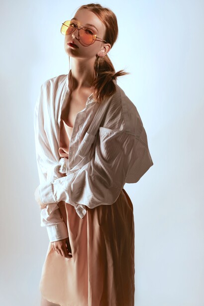 Mulher usa vestido com camisa oversized e óculos aviador de lente amarela