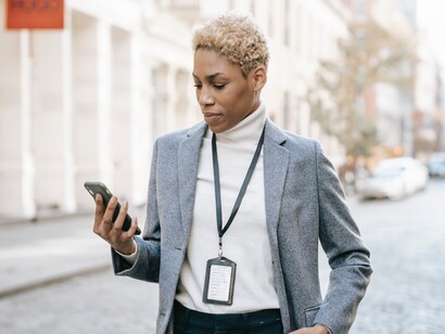 A woman looking at a mobile phone on a street