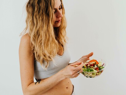 A woman in fitness clothes eating a salad