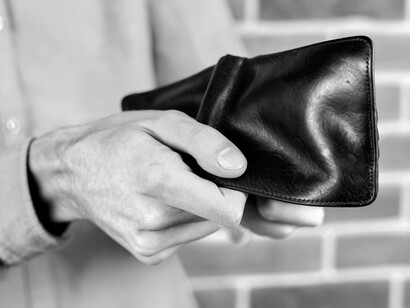 This simple yet powerful image of an empty wallet encapsulates the financial insecurity described within the article's narrative