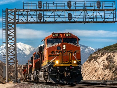 A heavy freight train moving through a mountain, representing the strategic importance of rail networks to supply chains and national resilience