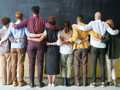 People standing in front of a chalkboard. Multiculturalism is the most useful weapon to fight prejudice