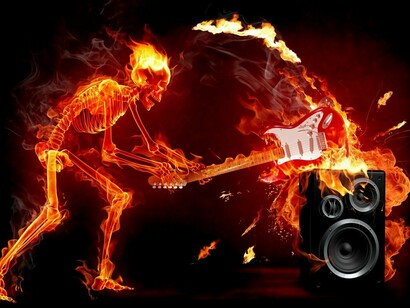 Un hombre en llamas destruye una guitarra contra un altavoz
