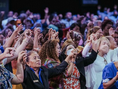 Fiéis participam de culto evangélico em momento de oração coletiva. A crescente aproximação entre religião e política tem redefinido discursos de poder e identidades sociais no mundo contemporâneo