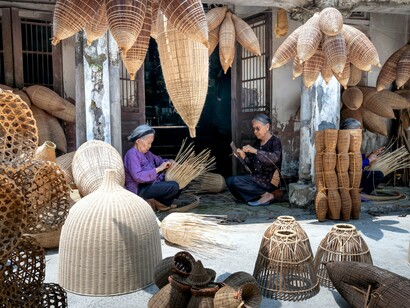 Local artisans in Vietnam weaving handcrafted baskets using traditional techniques, representing the value of supporting local communities through sustainable tourism