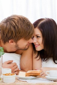 Pareja de enamorados desayunando en la cama