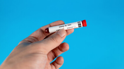 A human hand holding a Covid test