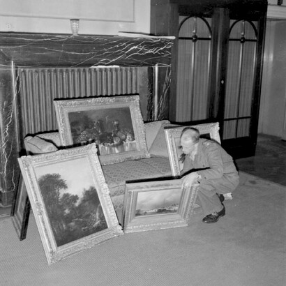 An officer checks a collection of paintings looted from the Netherlands