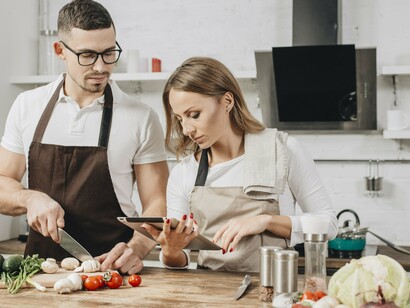 Casal prepara receita com ajuda de IA. Veja os principais ingredientes que você tem em casa e peça sugestões do que pode preparar com aqueles ingredientes. É possível também impor restrições se você tiver alguma, como por exemplo, pedir que a receita seja sem glúten ou vegetariana