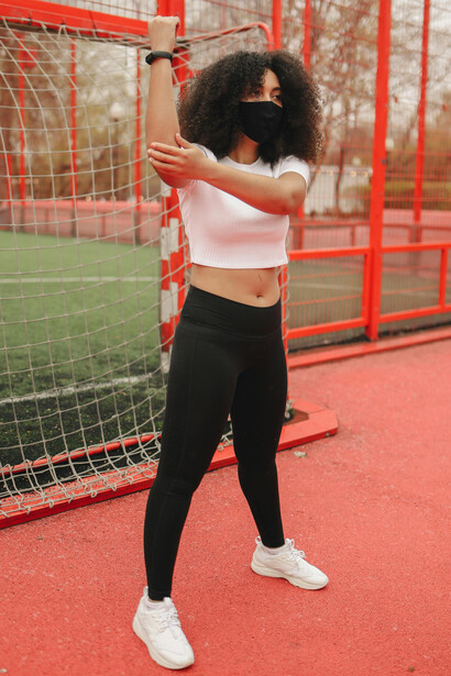 A woman exercising while wearing a face mask