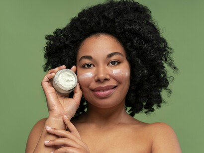 A woman holding a jar of facial cream, reflecting the benefits of barrier-supportive skincare