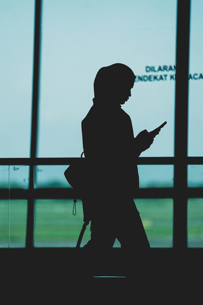 Surabaya, East Java, Indonesia, a woman’s silhouette with a backpack at an airport terminal