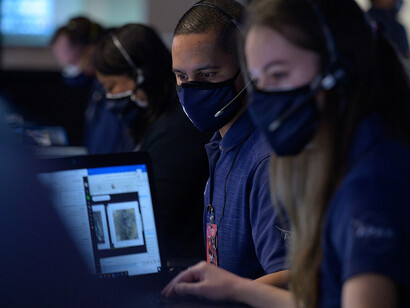 NASA’s Curiosity rover, part of the Mars Science Laboratory, is built to explore Mars for signs of microbial life. In this image, the rover examines a rock with its 2-meter arm in pre-launch tests