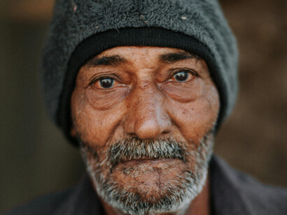 An grizzled elderly man looking into the camera
