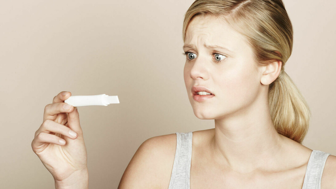 Una mujer mirando una prueba de embarazo