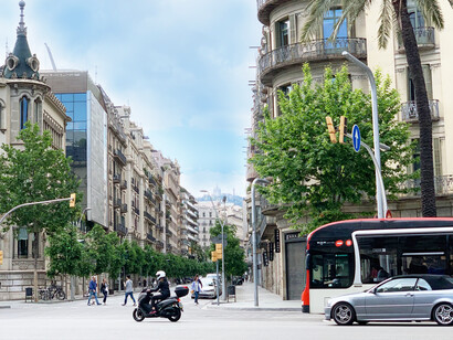A man on a scooter, in the middle of the streets of Barcelona Spain