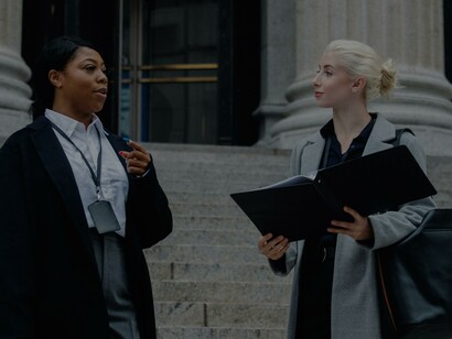 Elegantes e diversificadas parceiras de negócios femininas com documentos falando na rua