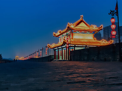 Experience the timeless charm of China's ancient Xian city wall as it glows magnificently under the night sky
