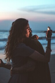 Casal usando o celular abraçados