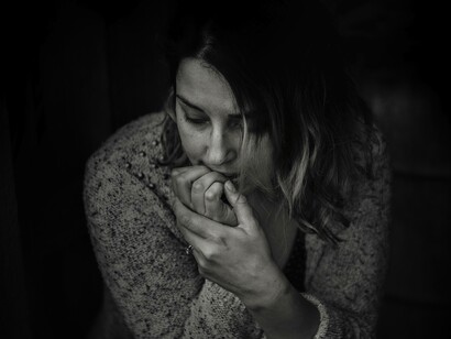 A woman biting her nails as she's anxious about losing her love