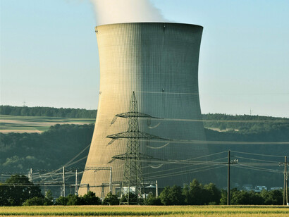 A large, single nuclear cooling tower on the countryside