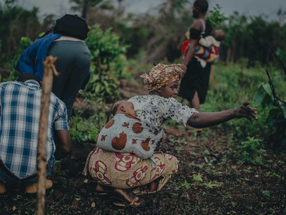 African women in the fields gardening and farming while their babies are sleeping soundly attached to their backs