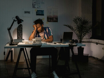 Exhausted man sitting behind his work desk