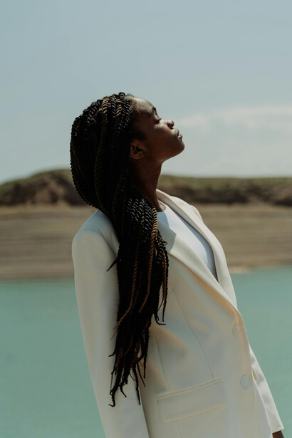 Woman with long braided hair wearing a white suit